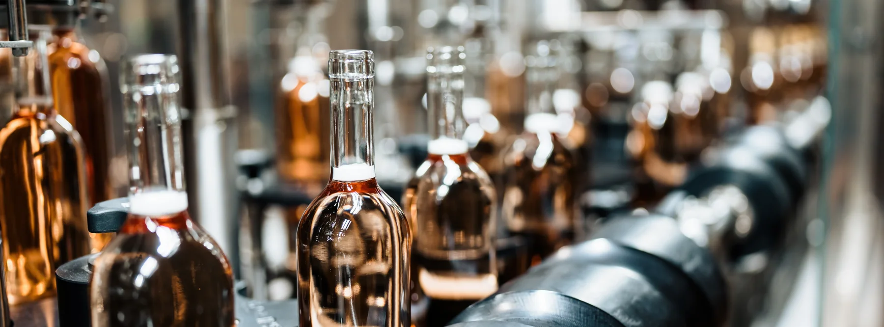 Roséwein-Flaschen im Abfüllkarussell – die Abfüllung läuft